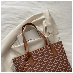 Top-down view of large tote bag with classic Y-pattern print on off-white fabric