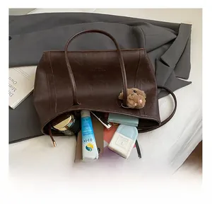 Détail montrant l'intérieur spacieux du cabas vintage marron foncé avec accessoires