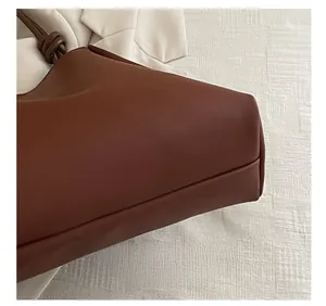 Close-up of the precision stitching on the bottom edge of a brown leather bucket bag