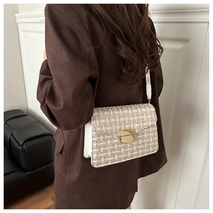 Détail du sac bandoulière en tweed avec boucle dorée et bandoulière blanche texturée