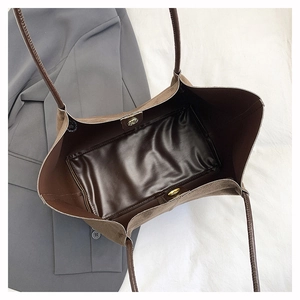 Dettaglio della borsa tote in pelle scamosciata marrone con chiusura magnetica e astuccio