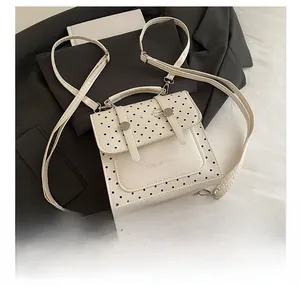 Detailed top view of white polka dot mini backpack with Tidal Dryness logo and PU texture