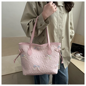 Détail du sac cabas rose texturé à bulles avec des nœuds brodés colorés et cordons de serrage