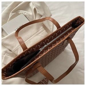 Detail view of large brown printed tote bag with zipper closure and spacious interior