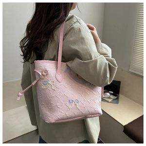 Pink pleated tote bag detail with colorful bow embroidery and textured surface design