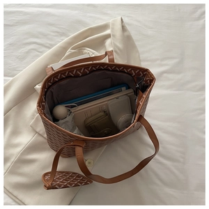 Detail view of large brown patterned tote bag showing interior storage for tablet and umbrella