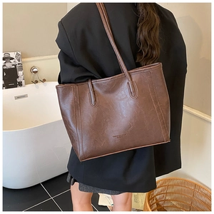 Gros plan d'un grand sac cabas marron foncé en cuir texturé avec fines bandoulières