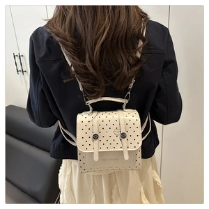 Detailed back view of a polka dot mini backpack worn by a model in a home setting