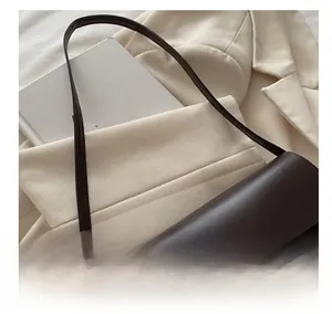 Detail of dark brown vintage leather shoulder bag with elegant gold metallic buckle