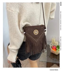 Close-up of bohemian brown fringe crossbody bag with metal rivets and ethnic ornament