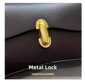 Detailed close-up of the vintage golden hardware clasp and fine stitching on leather bag