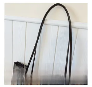 Detail showing the comfortable faux leather shoulder strap and plaid wool fabric texture