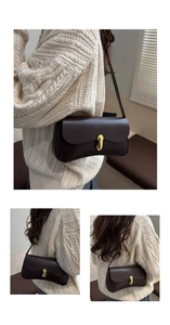Close-up of dark brown leather baguette bag featuring a sleek golden metal clasp
