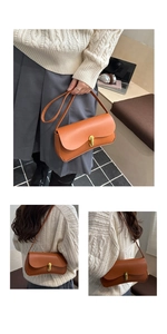Detail of orange-brown baguette bag with gold oval buckle and matte leather texture