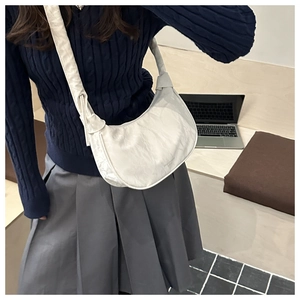 Detail of white pleated crescent bag featuring Ideas & Romance print on urban outfit