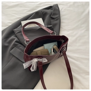 Détail du sac Boston bordeaux montrant la capacité intérieure et le nœud en dentelle