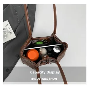 Detailed capacity view of the brown woven tote bag showing space for tablets and umbrellas