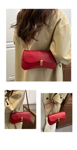 Close-up of bright red leather bag with elegant gold metal buckle and fine texture