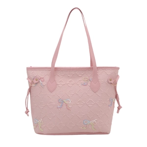 Pink quilted tote bag with colorful embroidered bows and slender dual handles