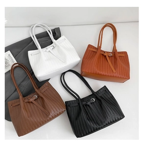 Detail of four woven leather tote bags in white, orange, brown and black with buckles