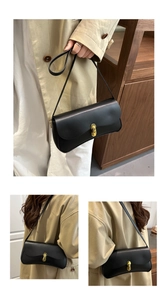 Detail of elegant black leather crossbody bag featuring a golden metal clasp and minimal design