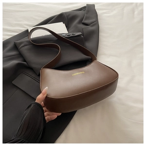 Detail of dark brown crescent bag with gold Fashion & Bags logo and smooth faux leather
