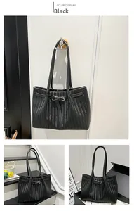 Detail of black woven tote bag featuring herringbone pattern and buckle closure strap