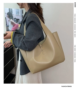 Detail of khaki leather tote bag featuring elegant gold metal clasp and spacious interior
