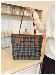 Détail du sac cabas à carreaux bleu et marron avec anses en cuir et étiquette mode