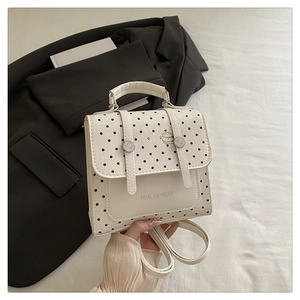 Detailed view of polka dot backpack with decorative straps and Tidal Dryness print
