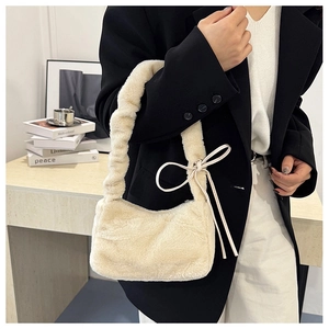 Detail of off-white faux fur shoulder bag featuring pleated strap and a delicate side bow