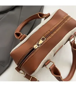 Close-up of the smooth golden zipper and woven fabric texture on a bowling handbag
