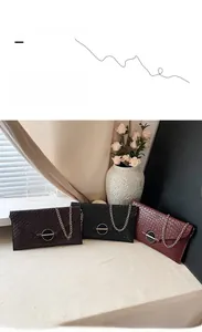 Close-up of woven texture envelope chain bag in dark brown, black, and wine red