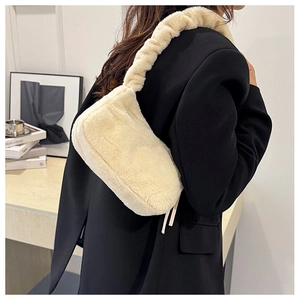 Detailed texture of plush cream faux fur shoulder bag with soft pleated strap design