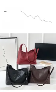 Three woven leather tote bags in burgundy, black and coffee colors on white display stand