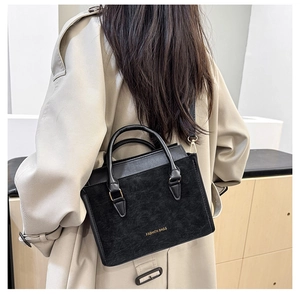 Detailed view of black mixed-texture crossbody bag with golden Fashion Bags lettering