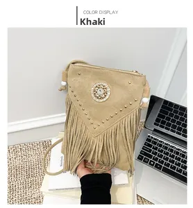 Detail view of khaki suede crossbody bag with gold studs, tassels and crystal buckle