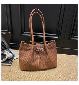 Detail of caramel zigzag weave texture and long leather handles on large tote bag