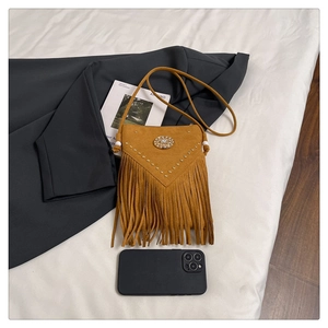 Détail du sac bohème en daim marron avec des clous métalliques et de longues franges