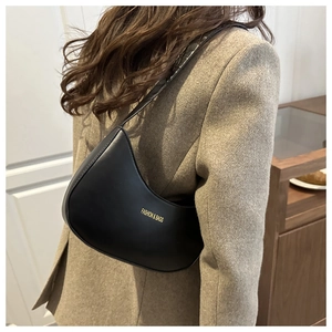 Detail of black crescent shoulder bag with gold embossed FASHION & BAGS lettering