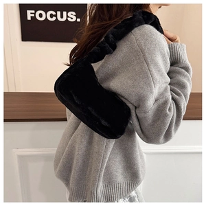 Close-up of black plush shoulder bag with fluffy texture and ruched cloud handle