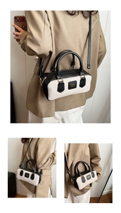 Detail of a minimalist contrast-colored handbag with gold hardware and logo patch