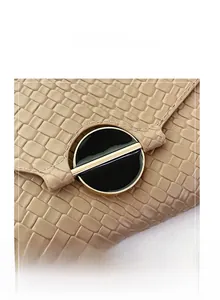 Close-up of beige woven texture bag featuring a unique round black and gold buckle