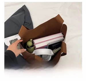 Top view of large brown tote bag showing spacious capacity with books and tablet inside