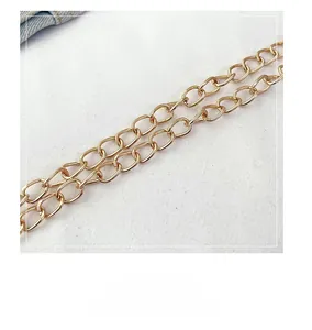 Close-up of polished golden metal chain links for stylish crossbody shoulder bags