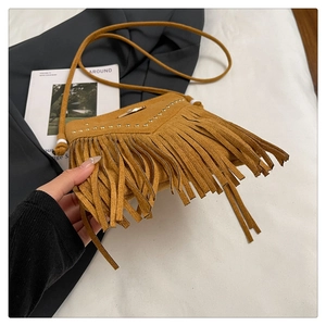 Vue détaillée du sac bandoulière en daim marron avec franges et rivets dorés de qualité