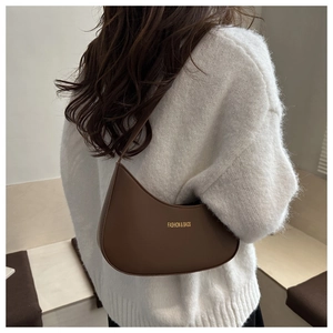 Detail of dark brown crescent shoulder bag in smooth leather on a model's back