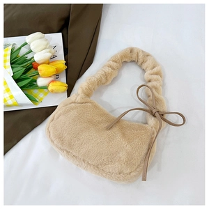 Detailed view of plush beige faux fur shoulder bag with leather bow and pleated texture
