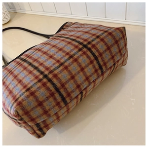 Vue détaillée du fond d'un sac cabas à carreaux montrant la texture en tweed tissé fin
