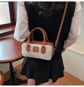 Detail view of canvas and brown leather crossbody bag with adjustable shoulder strap